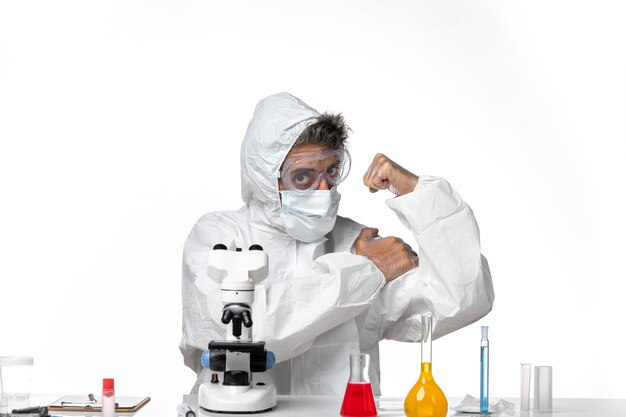 Front view male doctor in protective suit and mask flexing on white background pandemic covid health virus