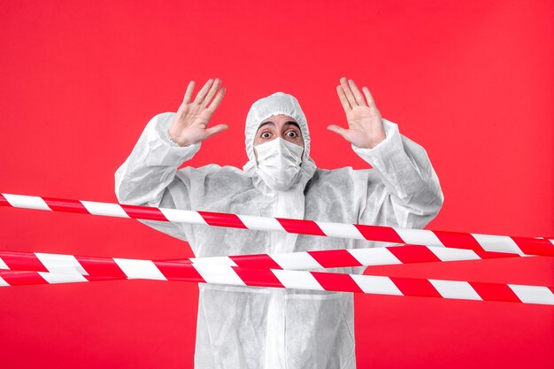 Front view male doctor in protective suit and mask on red background isolation quarantine covid- health emotion cure hospital