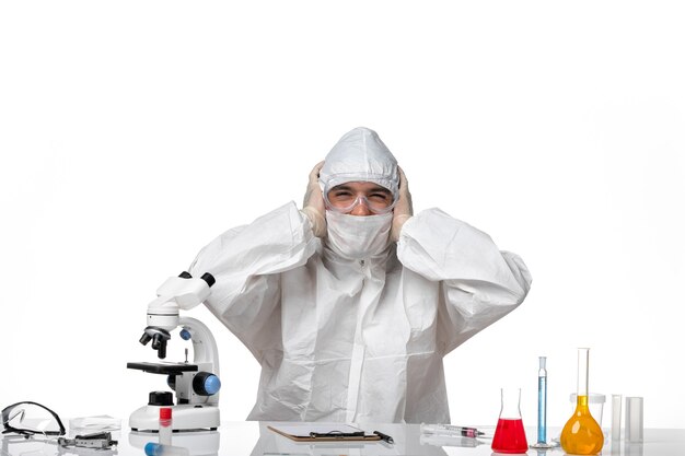 Front view male doctor in protective suit and with mask just smiling on white space