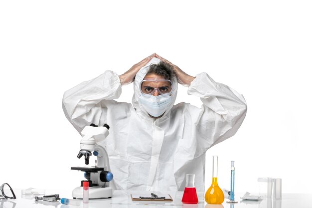 Front view male doctor in protective suit and with sterile mask posing on white