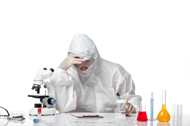 Front view male doctor in protective suit writing something on white space