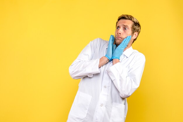 Front view male doctor scared on yellow background medic health covid pandemic