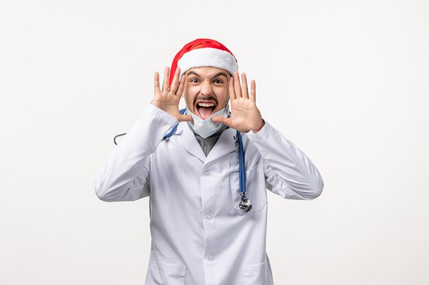 Front view of male doctor screaming on white wall