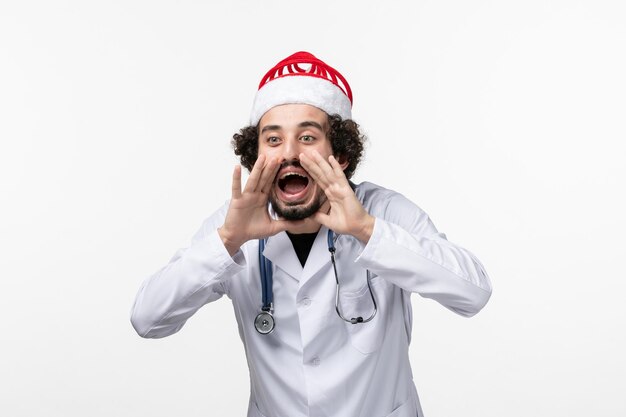 Front view of male doctor screaming on white wall