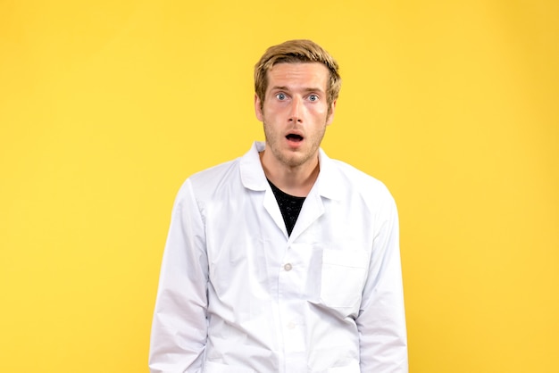 Front view male doctor shocked on yellow background human medic covid- emotion