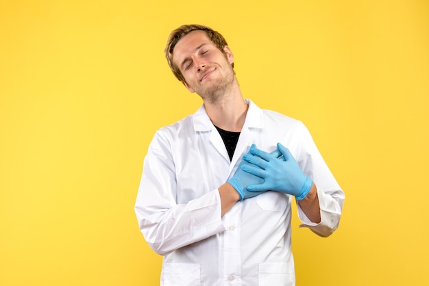 Front view male doctor smiling on yellow background medic human pandemic covid