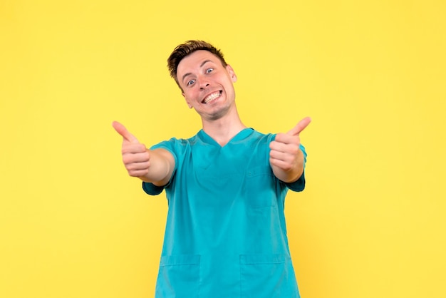 Free photo front view of male doctor smiling on yellow wall
