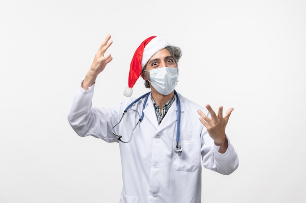 白い壁のウイルスcovid新年の休日に無菌マスクで正面図男性医師