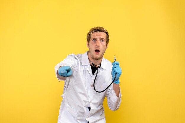正面図男性医師は黄色の背景に驚いた健康人間ウイルス薬