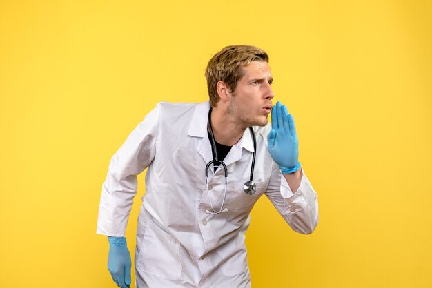 Front view male doctor talking to someone on yellow background health medic human virus