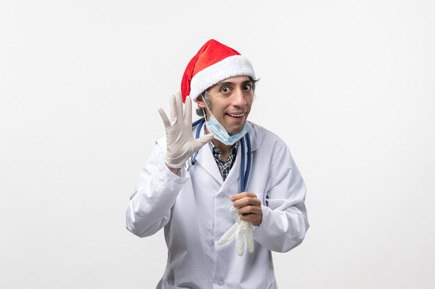 Front view male doctor wearing gloves on white desk virus holiday covid emotion