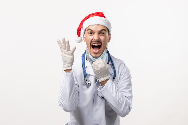 Front view of male doctor on white wall