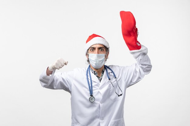 Free photo front view male doctor with big red sock on white desk virus covid- christmas holiday