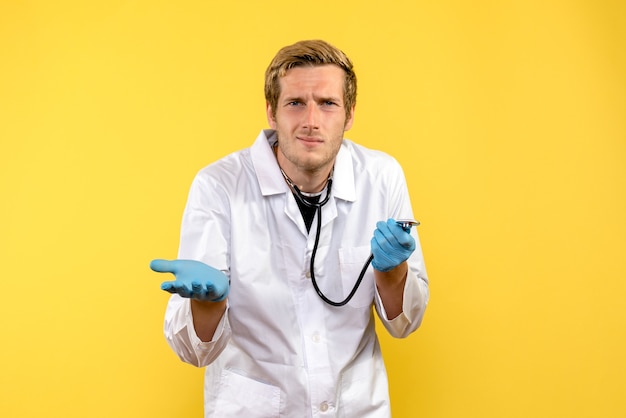 Вид спереди мужской доктор с растерянным лицом на желтом фоне, вирус здоровья, медик, эмоция