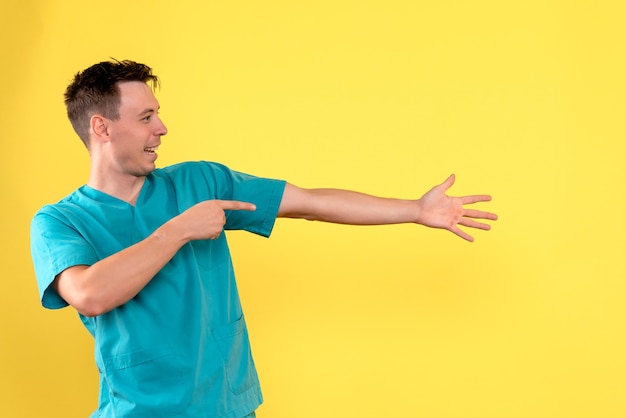 Front view of male doctor with excited expression on yellow wall