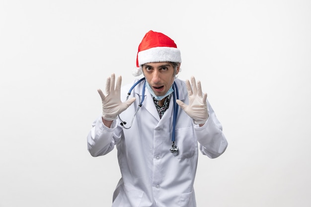 Вид спереди мужской доктор с перчатками на белой стене вирус праздник covid- эмоция