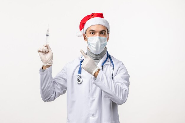 Free photo front view of male doctor with injection on the white wall