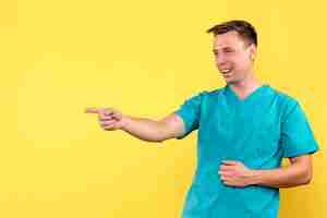 Free photo front view of male doctor with laughing expression on yellow wall