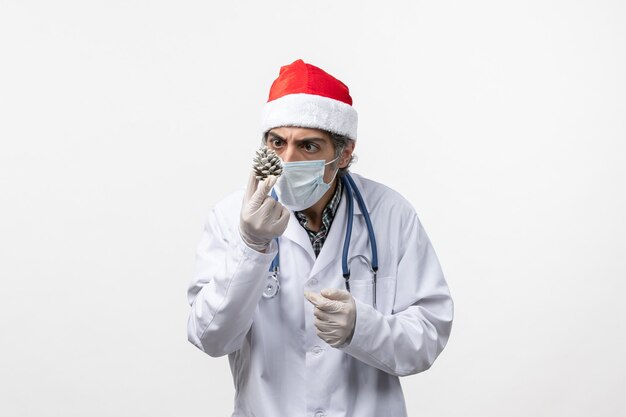 白い床に新年の木のおもちゃを持った正面図の男性医師