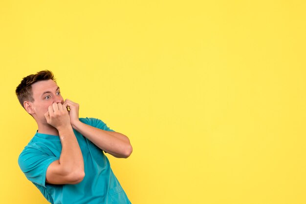 Front view of male doctor with scared expression on yellow wall