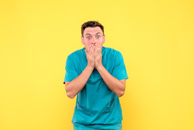 Front View of Male Doctor with Surprised Expression on Yellow Wall