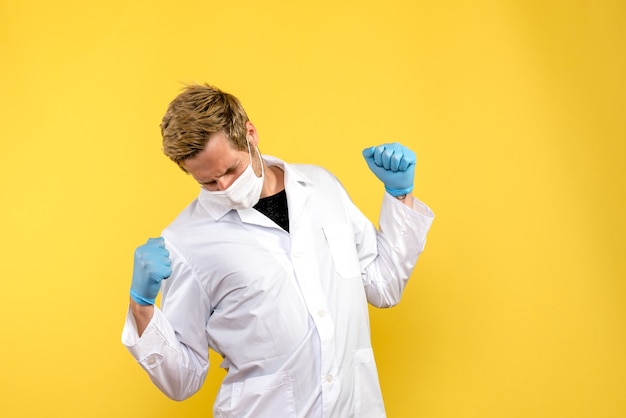 黄色の背景のパンデミックcovid-健康ウイルスであくびをしている正面図男性医師