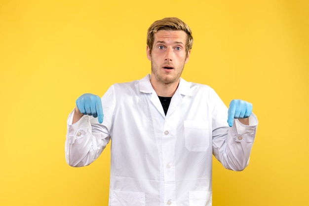 黄色の背景に正面図の男性医師covid-人間の病院の薬