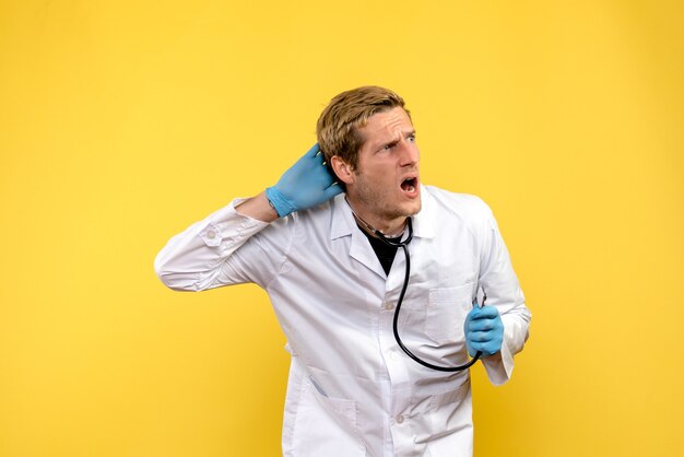 Вид спереди мужчина-врач на желтом фоне здоровья людей вирусный медик