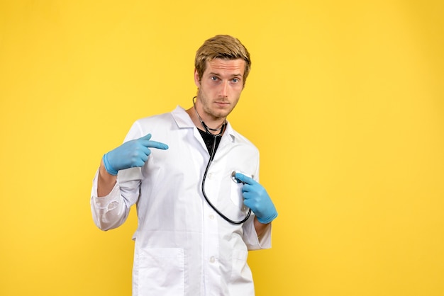 Front view male doctor on a yellow background virus health emotion medic