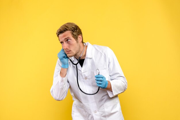 Вид спереди мужской доктор на желтом фоне вирус здоровья эмоции медик
