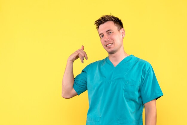 Вид спереди мужского врача на желтой стене