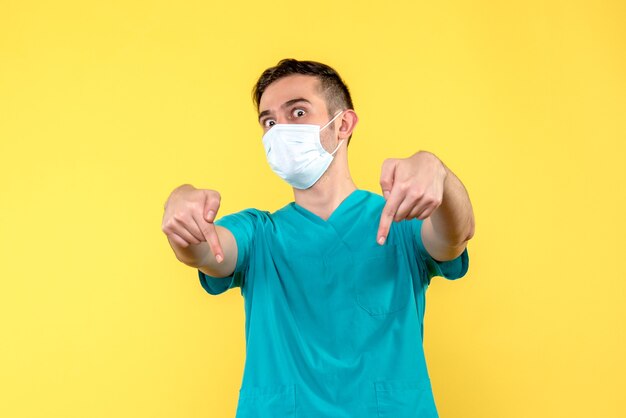 Front view of male doctor on yellow wall