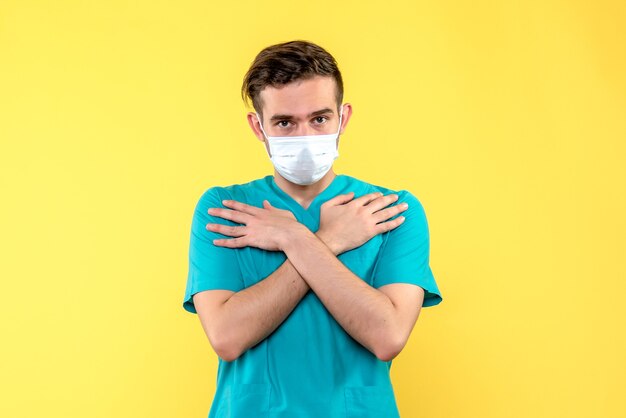 Front view of male doctor on yellow wall