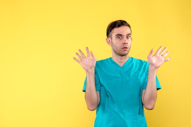 Front view of male doctor on yellow wall