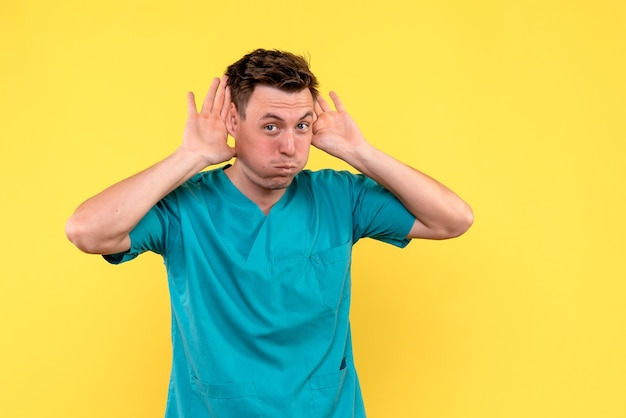 Front view of male doctor on yellow wall