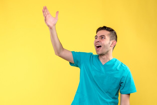 Front view of male doctor on yellow wall