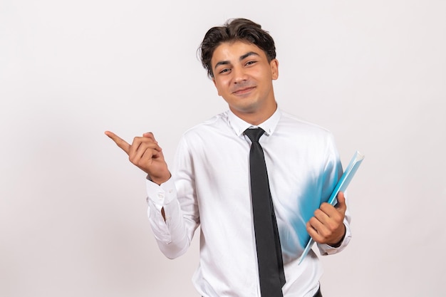 Front view male employee holding documents on white wall male business work job