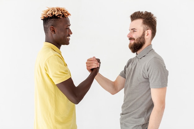 Free photo front view male friends shaking hands