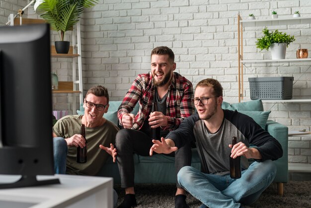 Front view of male friends watching sports together on tv