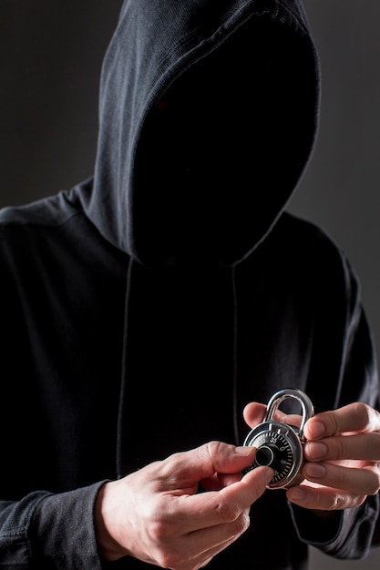 ロックを保持している男性のハッカーの正面図