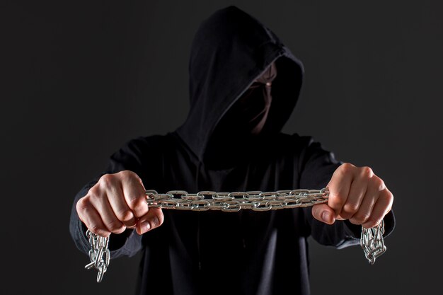 Вид спереди мужской хакер, держа металлическую цепь