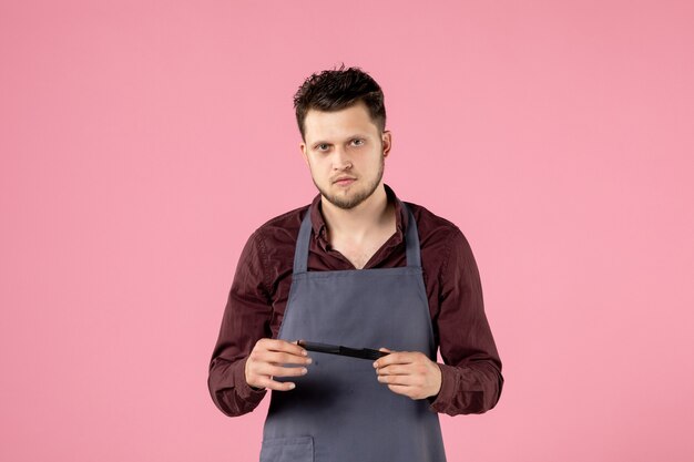 front view male hairdresser with hairbrush on pink background