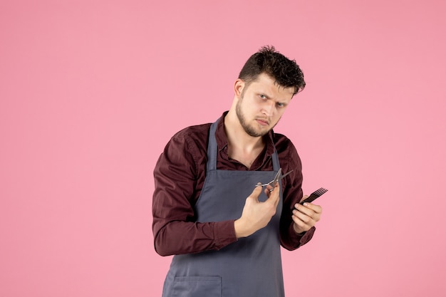 front view male hairdresser with hairbrush and scissors on pink background