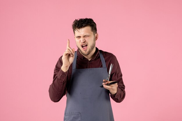 front view male hairdresser with hairbrush and scissors on pink background