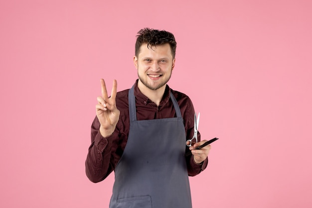 front view male hairdresser with hairbrush and scissors on pink background
