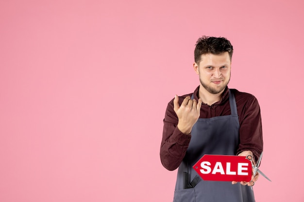 front view male hairdresser with red sale nameplate on pink background