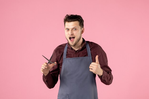 front view male hairdresser with scissors on pink background