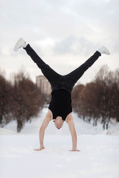 Front view of male hip hop performer standing on both hands