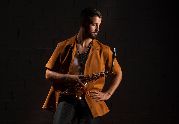 Front view of male musician posing with saxophone