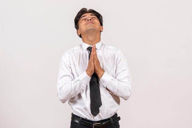 Front view male office worker praying on white wall office work job male human